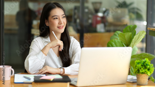 Thoughtful young asian businesswoman startup daydreaming about her work