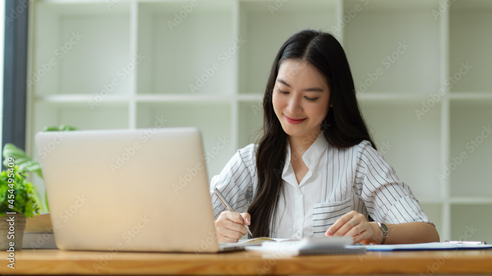 Happy and Charming business employee working in office, taking notes Happy and Charming business employee working in office, taking notes
