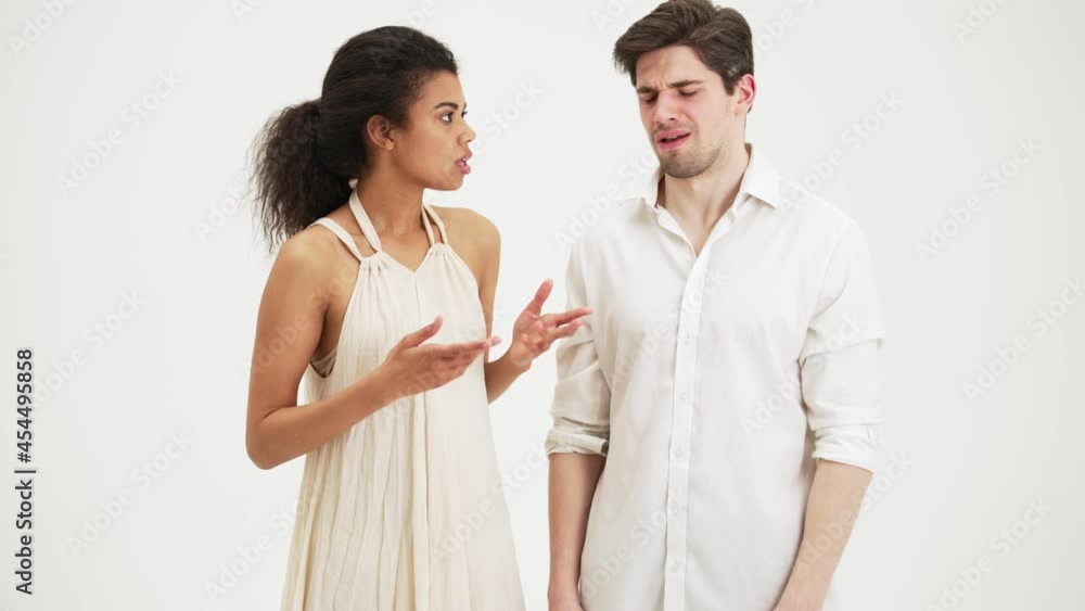 Serious couple man and woman talking standing isolated over white background in the studio Serious couple man and woman talking standing isolated over white background in the studio