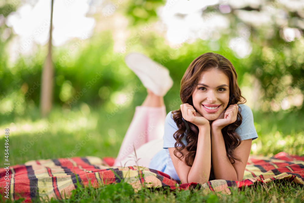 Full body photo of young attractive happy woman smile lie grass plaid blanket face hands outside outdoors park