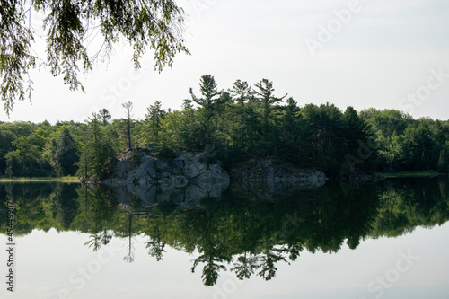 Lake reflecting surrounding trees and the daytime sky in Sudbury, Ontario, Canada photo