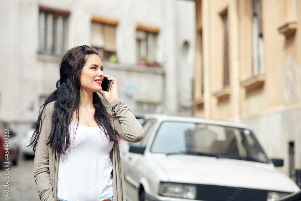 Young cute female using smartphone on the street. Young cute female using smartphone on the street.