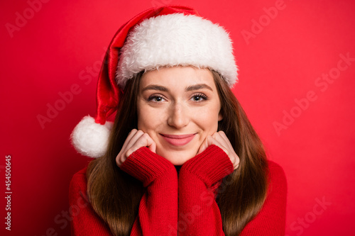 Photo of cute millennial lady hands face wear holiday sweater cap isolated on red color background