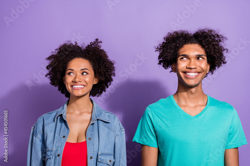 Photo of young dreamy positive dark skin couple people look empty space good mood isolated on violet color background