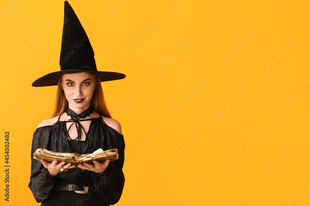 Fototapeta premium Young witch with spell book on color background