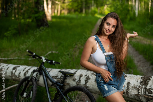 Young woman is resting while cycling in the forest