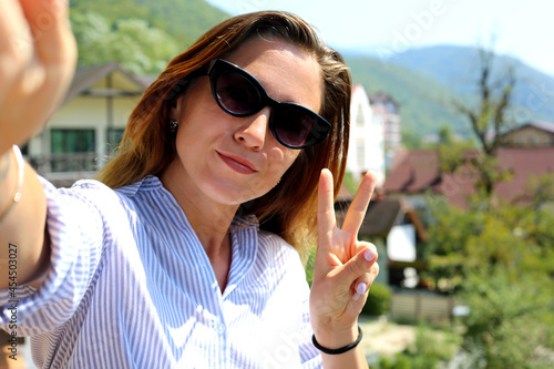 Pretty young woman making selfie at the balcony at the chalet in the muttons in Such Russia. photo