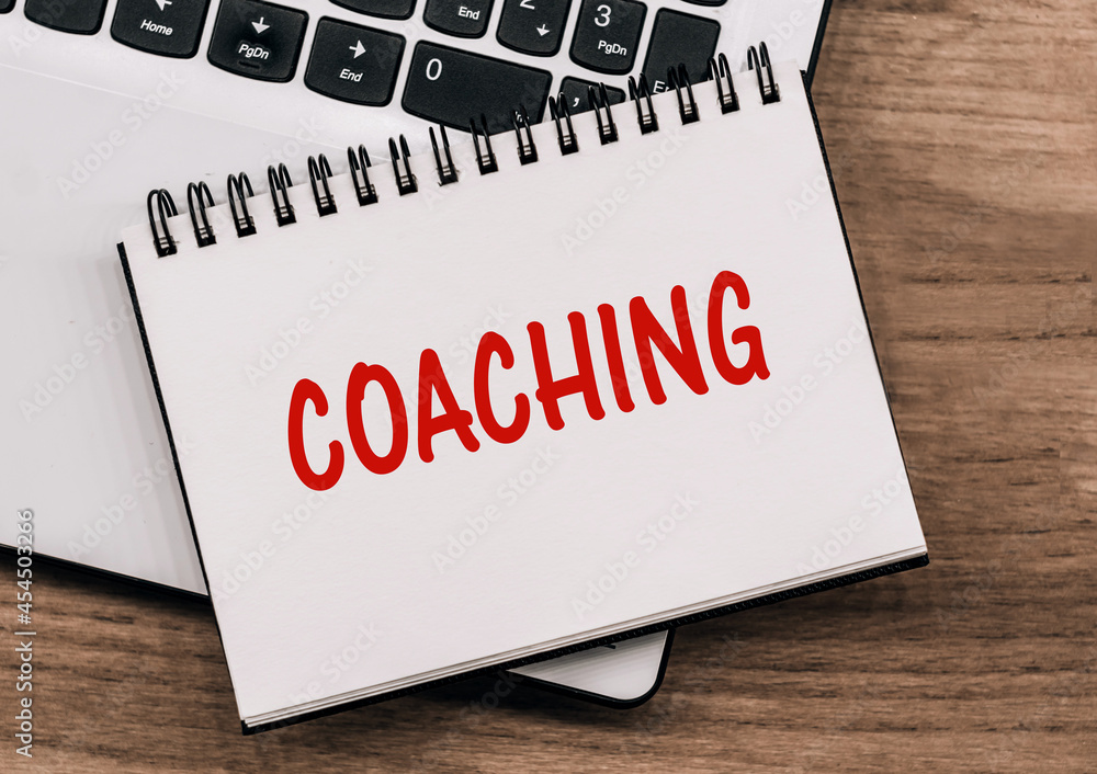 COACHING - inscription on notepad on laptop keyboard. COACHING - inscription on notepad on laptop keyboard.