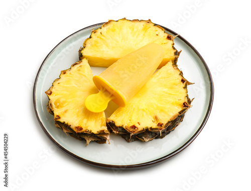Plate with tasty pineapple popsicle on white background