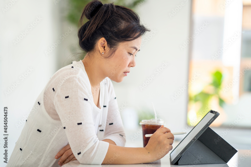 Young woman using tablet working indoor. Work from home concept. Young woman using tablet working indoor. Work from home concept.