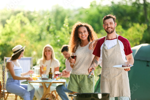 Young couple at barbecue party on summer day