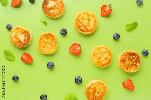 Cottage cheese pancakes  berries and mint on color background