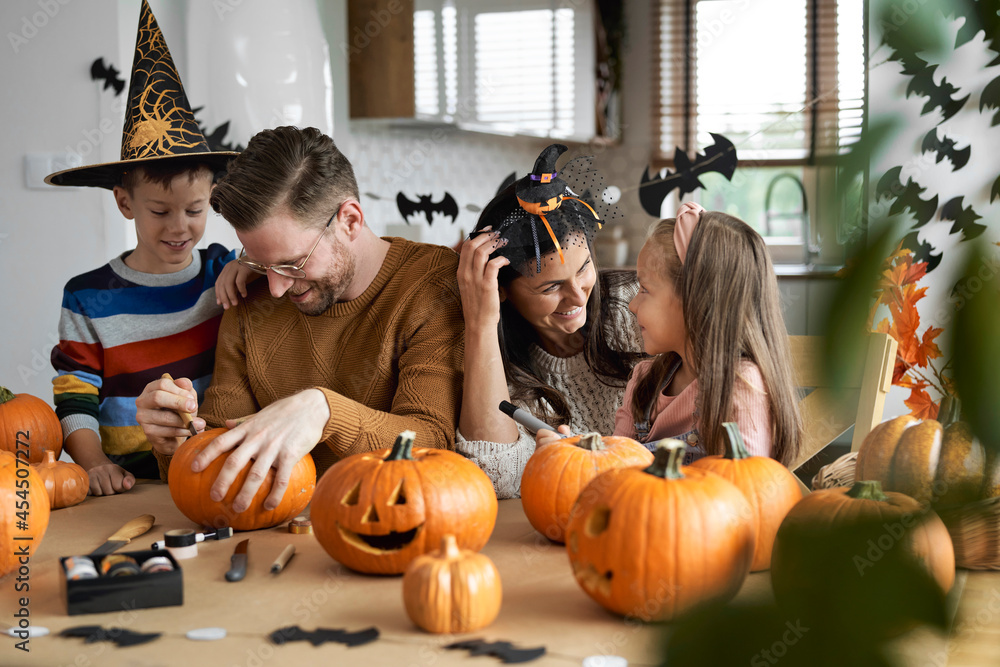 Fototapeta premium Happy family making jack-o-lantern