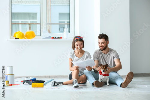Young couple with cute dog and palette samples planning design of their new house