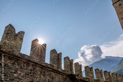 The sun filters through the battlements of Fenis Castle, Aosta Valley, Italy, in the early hours of the new day photo