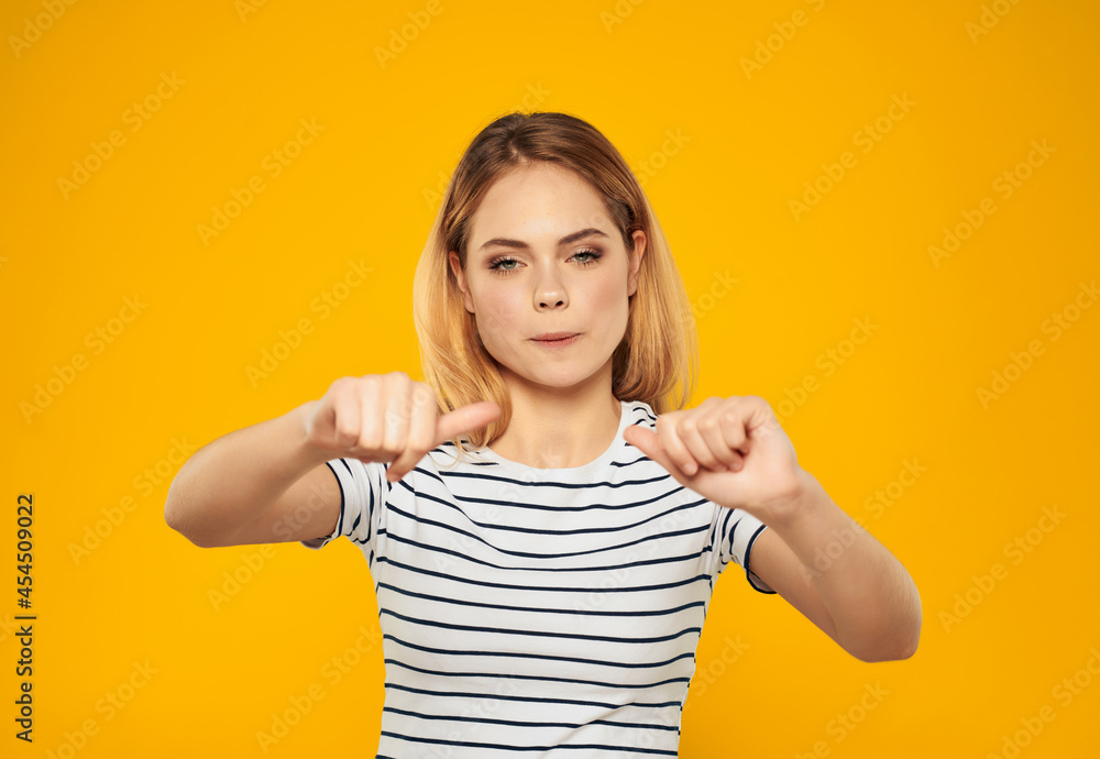 pretty woman in striped t-shirt gesturing with hands joy yellow background pretty woman in striped t-shirt gesturing with hands joy yellow background