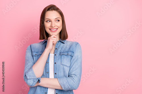 Photo portrait of girl smiling dreamy looking empty space thoughtful isolated pastel pink color background