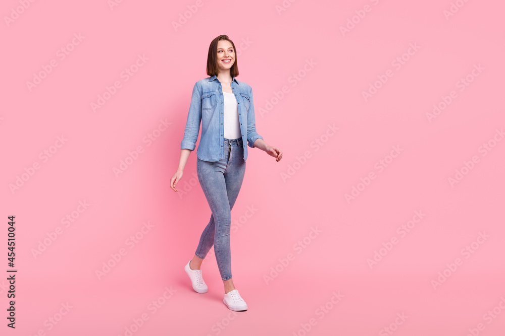 Full length body size photo girl smiling confident looking copyspace walking forward isolated pastel pink color background Full length body size photo girl smiling confident looking copyspace walking forward isolated pastel pink color background