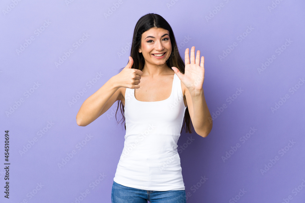 Young brunette woman over isolated purple background counting six with fingers Young brunette woman over isolated purple background counting six with fingers