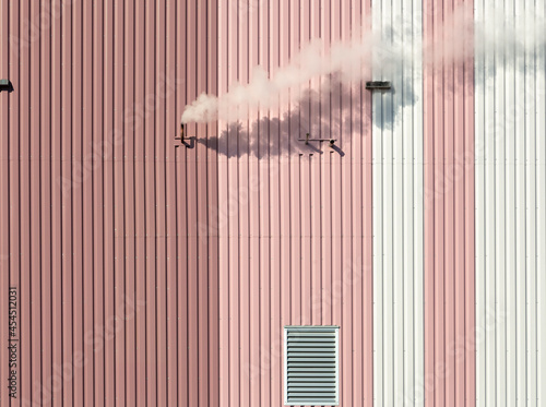 Fényképezés Cloud of smoke coming out of a pipe on a pink and white building