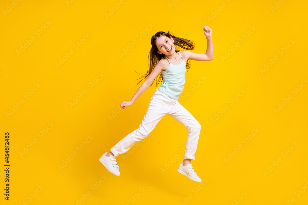 Full size photo of happy cute little girl jump up good mood weekend rest isolated on yellow color background