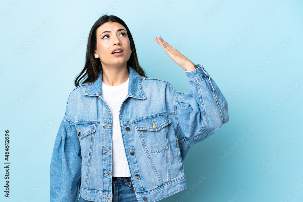 Young brunette girl over isolated blue background with tired and sick expression Young brunette girl over isolated blue background with tired and sick expression