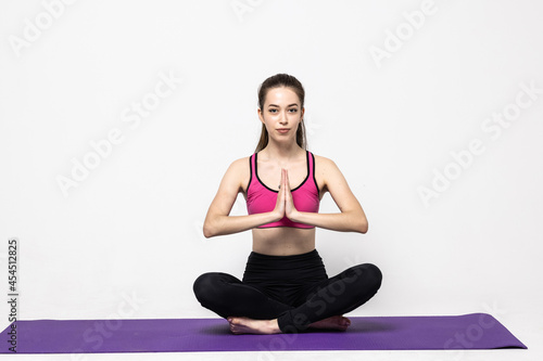 Young woman with closed eyes meditating over white background
