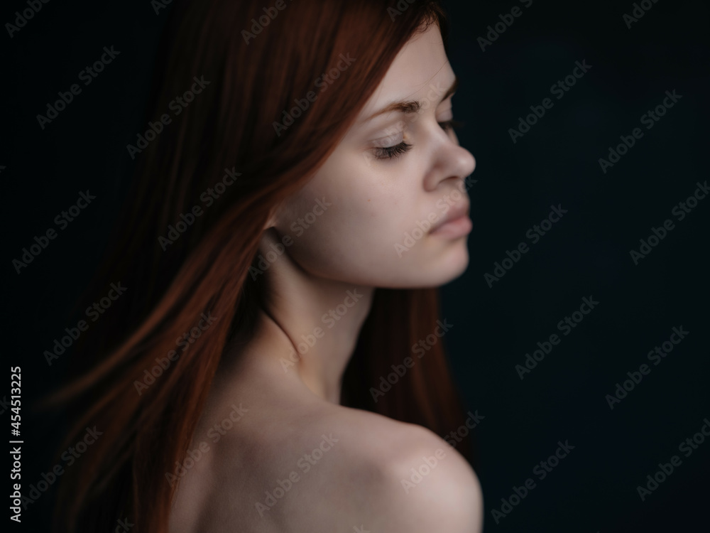 red-haired woman naked shoulders dark background glamor red-haired woman naked shoulders dark background glamor