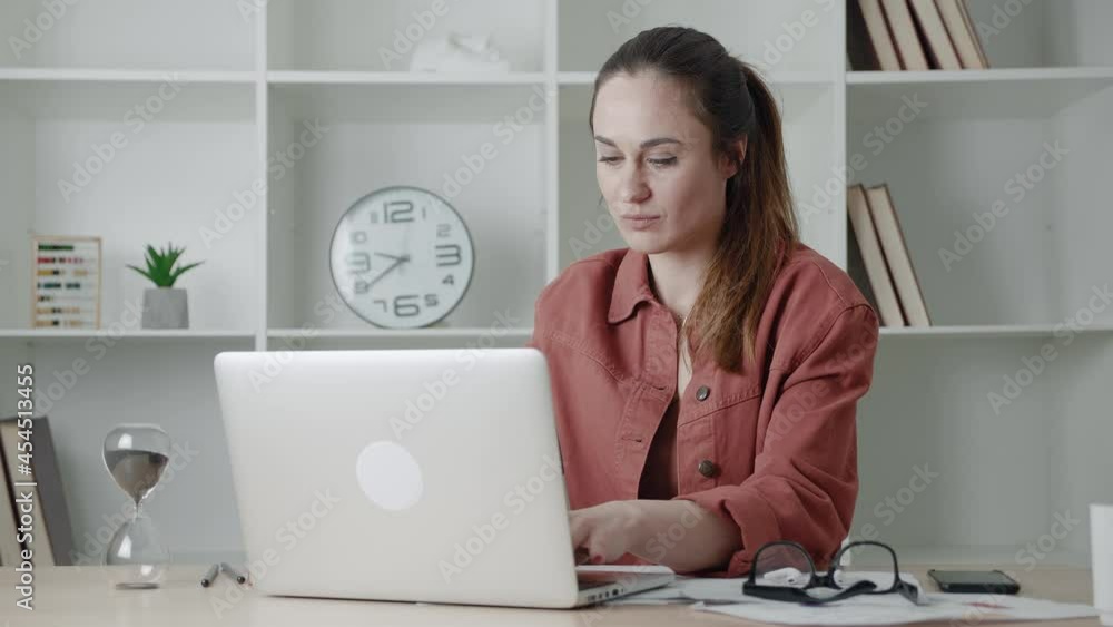 Businesswoman sitting from the desk and looking screen laptop. Female typing the text in modern office. Businesswoman sitting from the desk and looking screen laptop. Female typing the text in modern office.