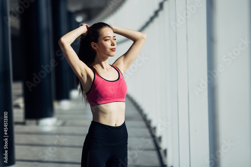 Sporty slim woman with ponytail fitness woman enjoys workout exercise at gym