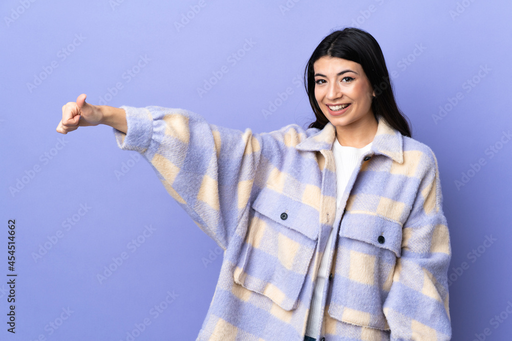 Young brunette woman over isolated purple background giving a thumbs up gesture Young brunette woman over isolated purple background giving a thumbs up gesture