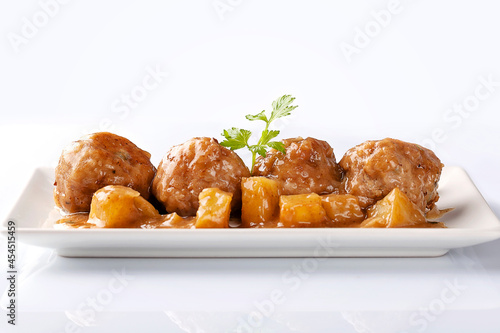 Front view of meatballs with whine wine sauce and potatoes on white background