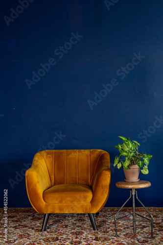 Interior element, yellow empty armchair against blue wall background, space for text, copy space