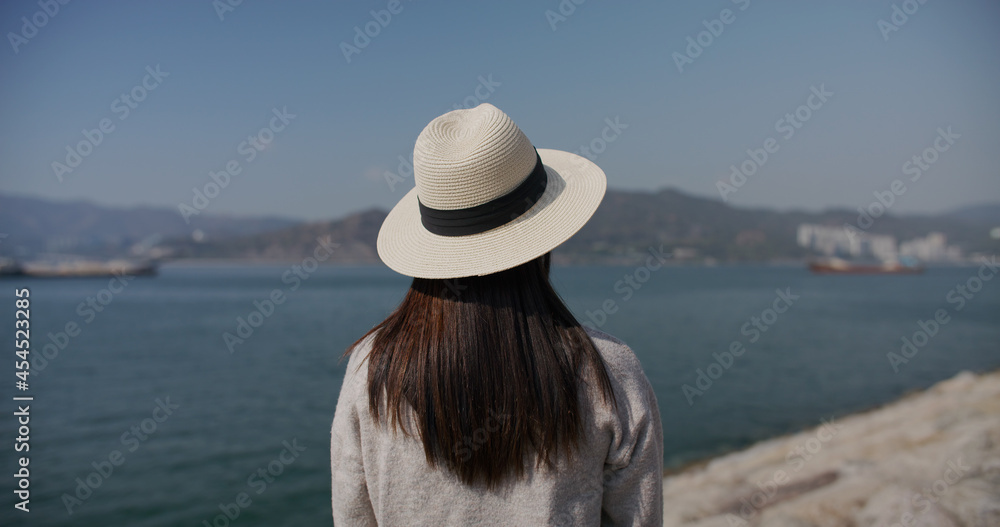 Woman wear straw hat and look at the sea Woman wear straw hat and look at the sea