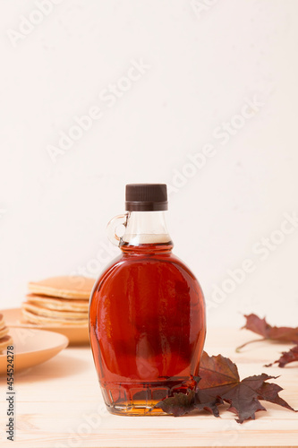Beautiful maple syrup in a bottle. Maple leaves 