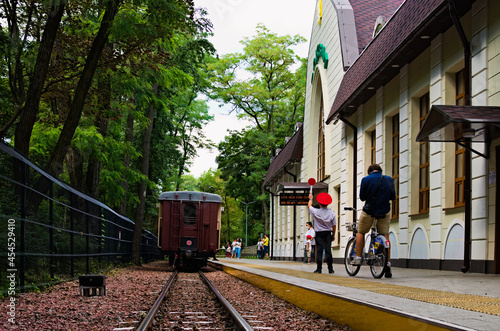 Main railway station of Kyiv Children's Railway in Syretsky Park. Train departure is allowed. The stationmaster allowed the departure. The train departs from the station photo