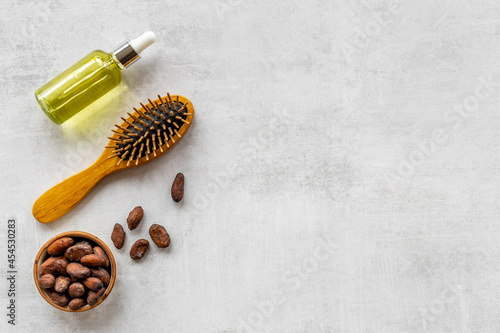 Cocoa oil for hair care with wooden hair brush. Top view