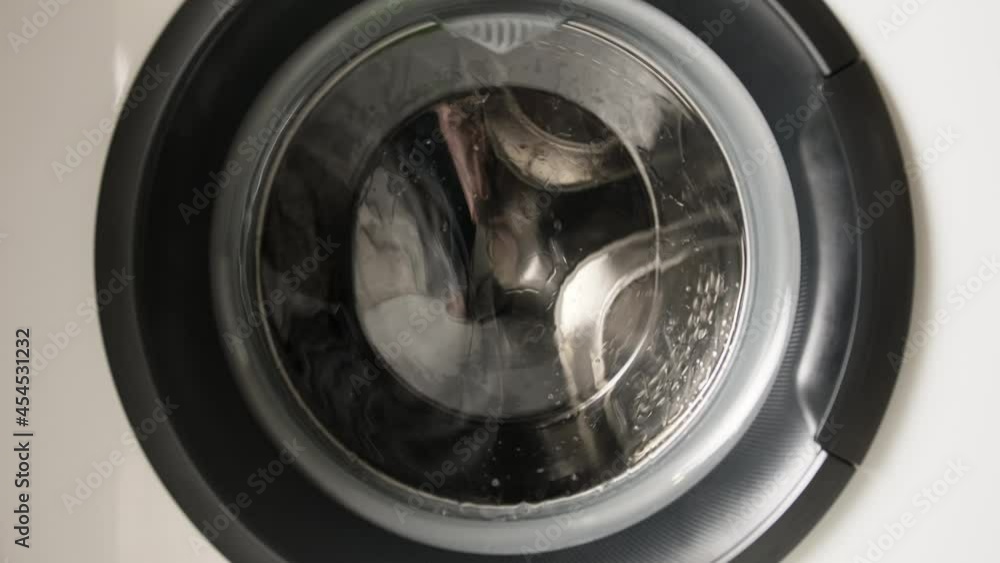 Spin drum of washing machine with clothes inside during laundry process. Closeup view Spin drum of washing machine with clothes inside during laundry process. Closeup view
