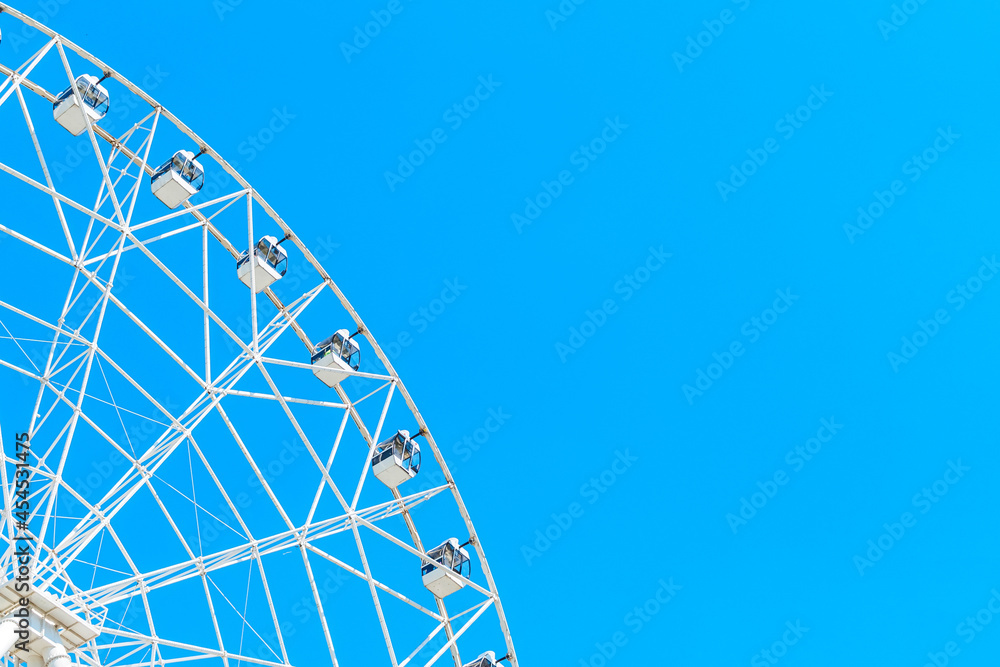 white ferris wheel on a background of blue sky without clouds, copy space