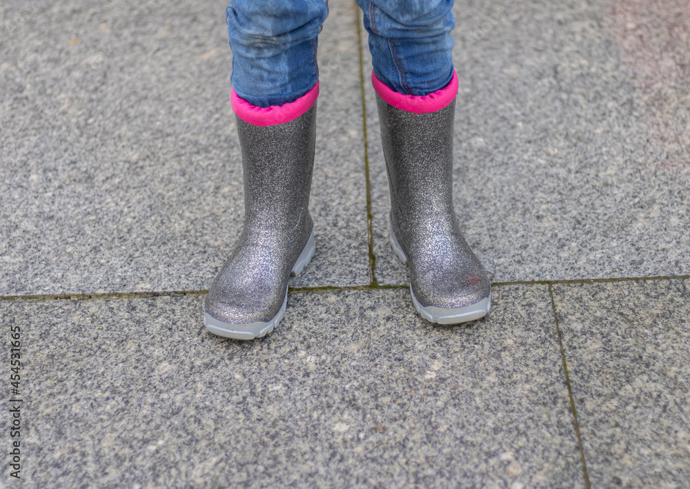 kids feet in rubber boots in the raining day kids feet in rubber boots in the raining day