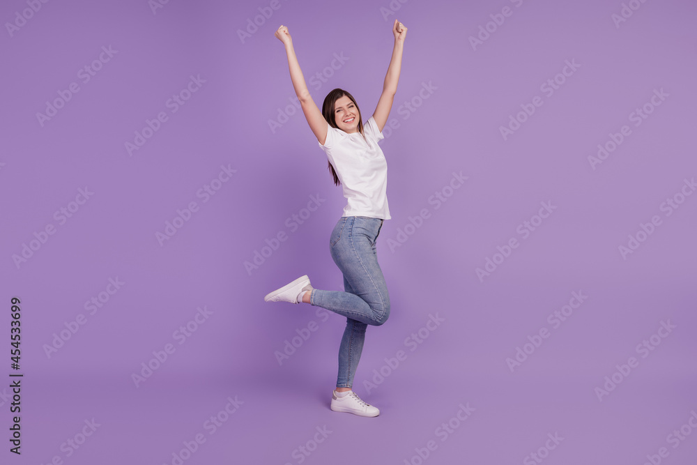 © Tetiana - Photo of positive lucky girl raise fists win isolated over purple background © Tetiana - Photo of positive lucky girl raise fists win isolated over purple background