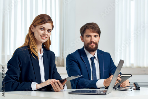 man and woman managers talking at the table in front of laptop office technology