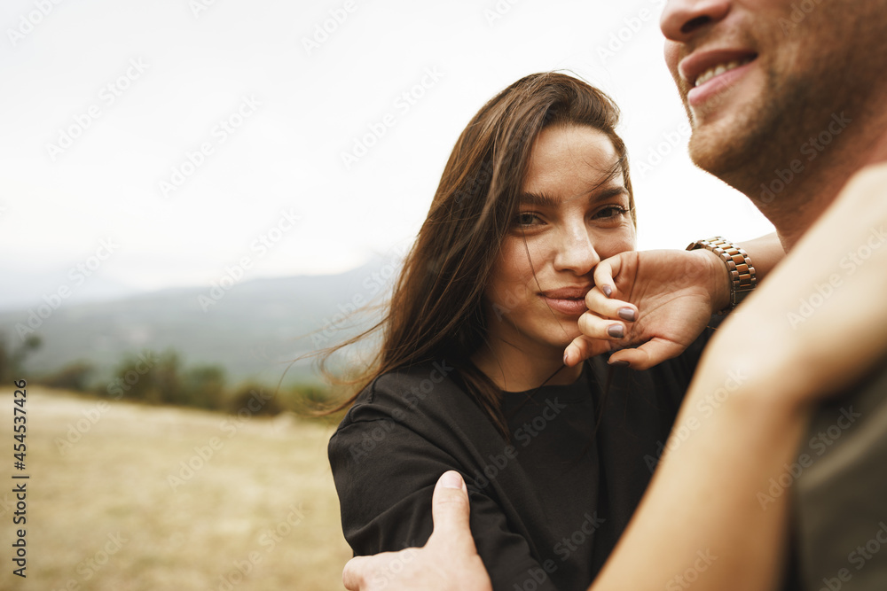 Happy couple in love hugging smiling and having fun in the mountains