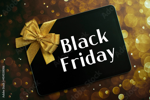 Text Black Friday in a tablet and a gold ribbon