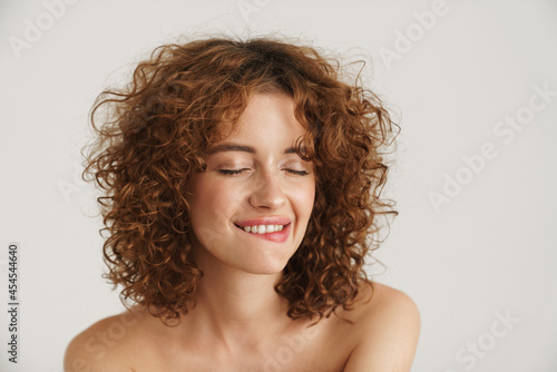 Smiling young curly woman with bare shoulders