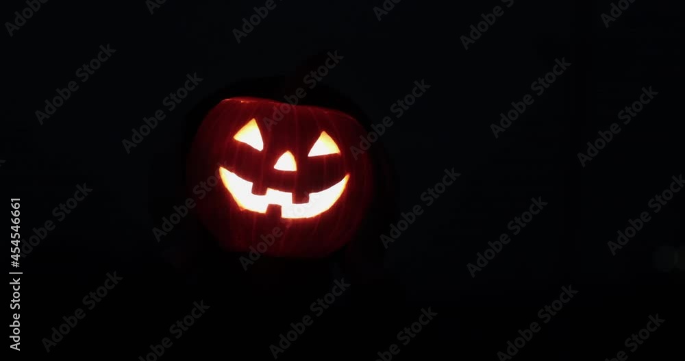 Glowing halloween pumpkin lantern flies in the dark, slowly approaching and frightening with its appearance. Glowing halloween pumpkin lantern flies in the dark, slowly approaching and frightening with its appearance.