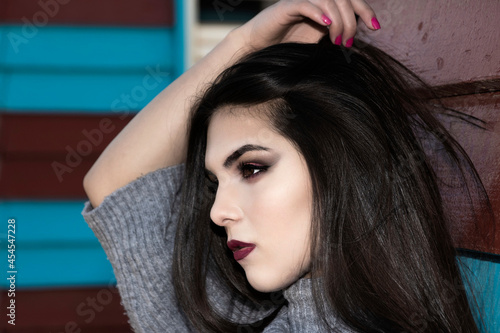 portrait of a pretty black haired woman with a blue and red background