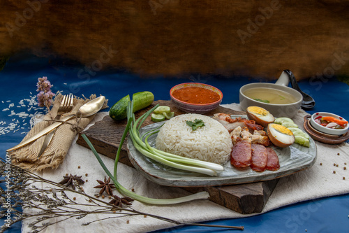 Fotografie Red pork with rice (Kao Moo Dang) : Thai Style Red Barbecue Pork, duck egg and crispy pork belly, sliced cucumber with red sauce and broth