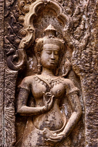 Detail of bas relief sculpture the wall of the ancient Ta Prohm temple in the Angkor Thom Area, Siem Reap, Cambodia.