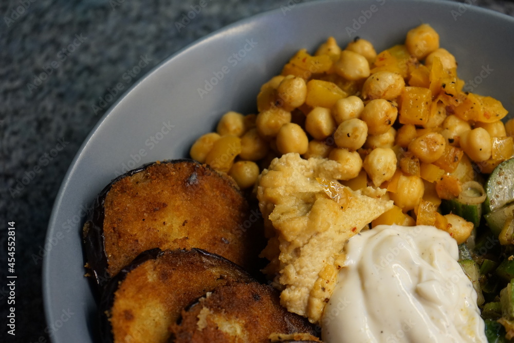 Vegan hummus bowl with crispy eggplant chickpeas peppers vegetables fresh salad Vegan hummus bowl with crispy eggplant chickpeas peppers vegetables fresh salad